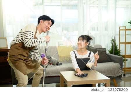 Young couple enjoys a playful moment while organizing their living room Young couple enjoys a playful moment while organizing their living room 123070200