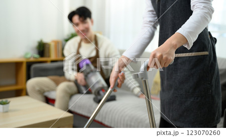Happy asian couple enjoys tidying up their home on weekend 123070260