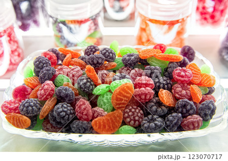 Pile of colorful fruit hard candy in the shape of berries and fruits in glass bowl. Natural sweets selective focus. Pile of colorful fruit hard candy in the shape of berries and fruits in glass bowl. Natural sweets selective focus. 123070717