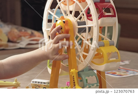 Child plays with a plastic constructor at home on table. Children and educational games. Animals of Africa and an amusement park.  123070763
