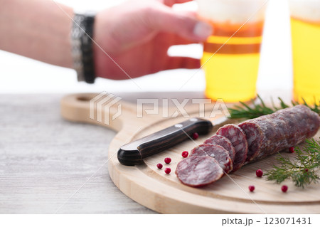 カッティングボードの上にのせた熟成サラミ ピンクペッパーとローズマリー カッティングボードの上にのせた熟成サラミ ピンクペッパーとローズマリー 123071431