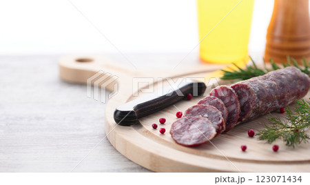 カッティングボードの上にのせた熟成サラミ ピンクペッパーとローズマリー カッティングボードの上にのせた熟成サラミ ピンクペッパーとローズマリー 123071434
