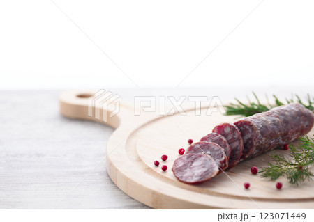 カッティングボードの上にのせた熟成サラミ　ピンクペッパーとローズマリー 123071449