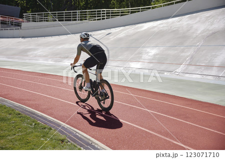 Healthy man cyclist exercising on bicycle on sprint track Healthy man cyclist exercising on bicycle on sprint track 123071710