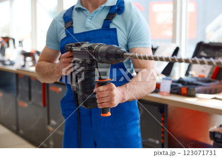 Male worker standing with electric power drill manual tool 123071731