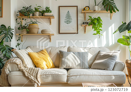 Interior fragment of a modern living room with a comfortable sofa, houseplants and shelves 123072719