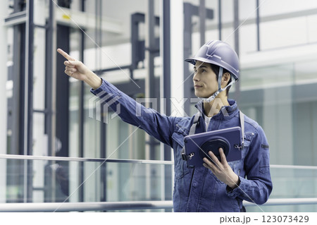 ヘルメットを被ってタブレットを持つ建設現場の若い男性作業員 撮影協力:スカパー東京メディアセンター ヘルメットを被ってタブレットを持つ建設現場の若い男性作業員 撮影協力:スカパー東京メディアセンター 123073429