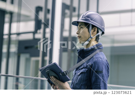 ヘルメットを被ってタブレットを持つ建設現場の若い男性作業員 撮影協力:スカパー東京メディアセンター ヘルメットを被ってタブレットを持つ建設現場の若い男性作業員 撮影協力:スカパー東京メディアセンター 123073621