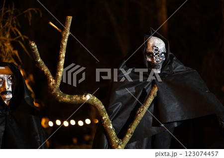 Scary Halloween witch with red eyes in a black cloak in a gloomy environment Scary Halloween witch with red eyes in a black cloak in a gloomy environment 123074457