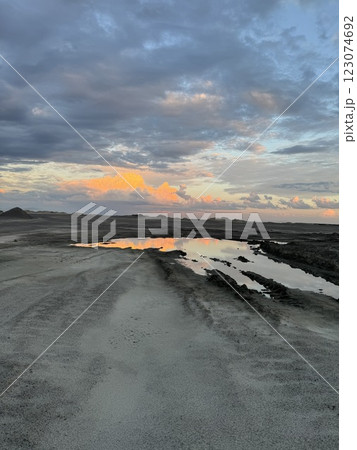 Reflective water in barren landscape with sunset sky Reflective water in barren landscape with sunset sky 123074692