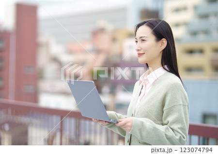 都会とパソコンとビジネスウーマンのイメージ 123074794