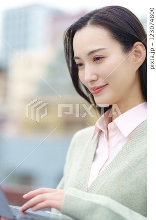 都会とパソコンとビジネスウーマンのイメージ 123074800