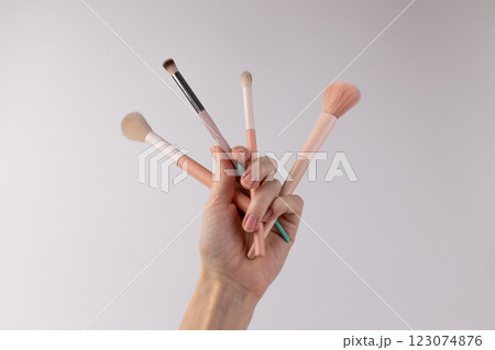 Aesthetic Display of Makeup Brushes Captured in a Hand Against a Simple Background for Beauty and Cosmetic Enthusiasts Aesthetic Display of Makeup Brushes Captured in a Hand Against a Simple Background for Beauty and Cosmetic Enthusiasts 123074876