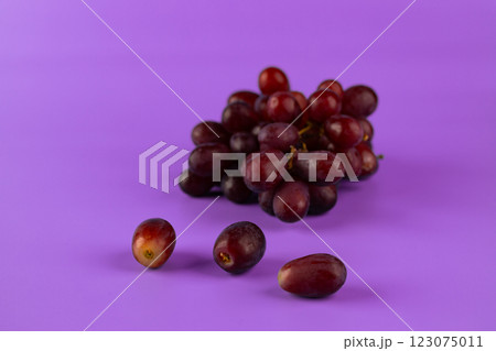 A Vibrant Display of Fresh Grapes on a Bright Purple Background, Capturing the Essence of Healthy Living and Nature's Sweet Bounty in a Beautifully Styled Arrangement 123075011