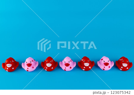 A Colorful Display of Charming Rubber Fish Toys in Shades of Pink and Red on a Bright Blue Background Perfect for Creative Play and Relaxation 123075342
