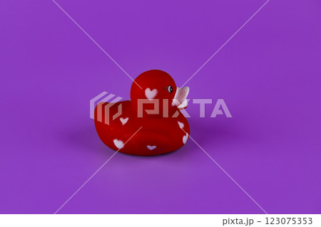 Charming Red Rubber Duck with Heart Patterns on a Vibrant Purple Background for an Adorable and Playful Bath Time Experience and Decorative Touch Charming Red Rubber Duck with Heart Patterns on a Vibrant Purple Background for an Adorable and Playful Bath Time Experience and Decorative Touch 123075353