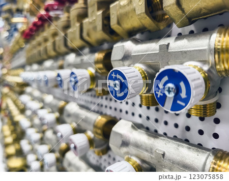 Detailed view of polished plumbing valves arranged in an organized display at a hardware store 123075858