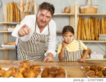 Uncle and girl are laughing, having fun, doing prank in trading floor of bakery store Uncle and girl are laughing, having fun, doing prank in trading floor of bakery store 123075969