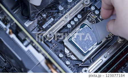 girl programmer apply thermal paste on the computer processor, macro photography 123077184