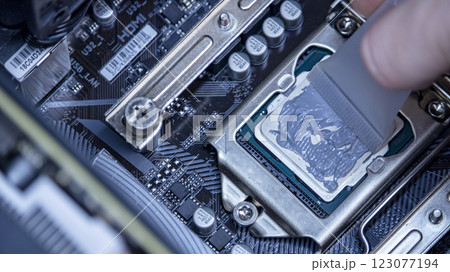 girl programmer apply thermal paste on the computer processor, macro photography girl programmer apply thermal paste on the computer processor, macro photography 123077194