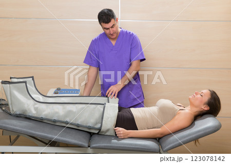 Doctor checking legs pressotherapy machine on woman 123078142