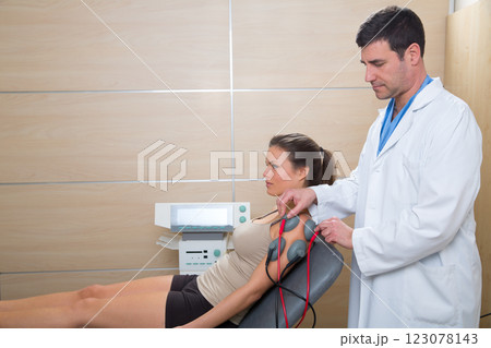 Doctor therapist checking muscle electrostimulation to woman Doctor therapist checking muscle electrostimulation to woman 123078143