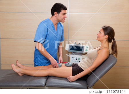 Doctor therapist checking muscle electrostimulation to woman 123078144