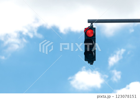 Red traffic light on blue cloudy sky background 123078151