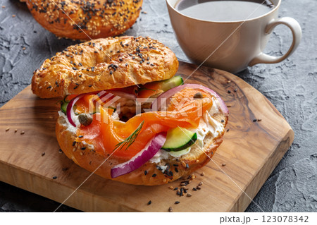 Lox bagel. A sandwich with smoked salmon, cucumbers and onions Lox bagel. A sandwich with smoked salmon, cucumbers and onions 123078342