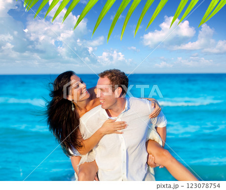 couple in love piggyback playing in beach 123078754