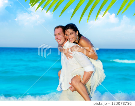 couple in love piggyback playing in beach 123078756