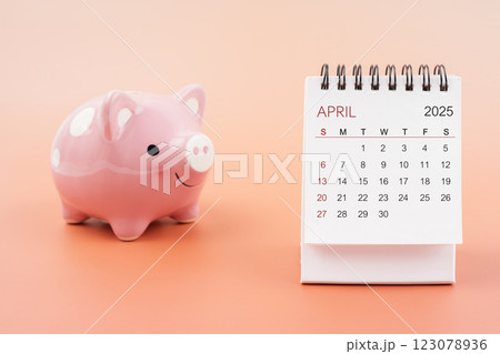 Desk calendar for April 2025 and pink piggy bank. Desk calendar for April 2025 and pink piggy bank. 123078936