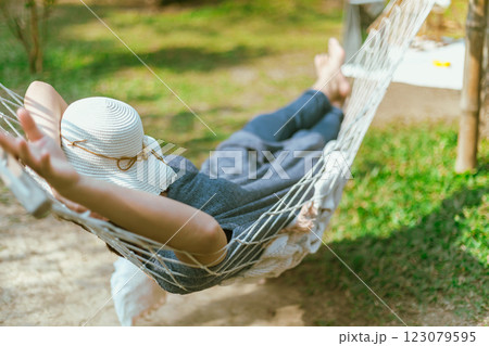 Women covering face with hat sleeping on hammock 123079595