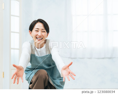 手を広げて子供を迎える女性保育士 手を広げて子供を迎える女性保育士 123080034
