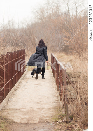 Woman and her dogs on an rusty bridge on a cloudy day Woman and her dogs on an rusty bridge on a cloudy day 123081318