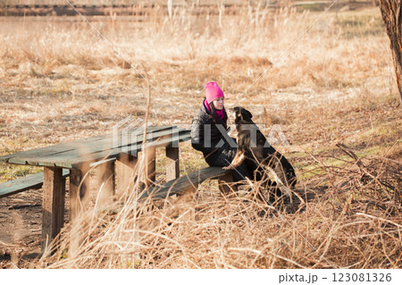 Woman in park teaches dog to give high five on sunny day in early spring Woman in park teaches dog to give high five on sunny day in early spring 123081326