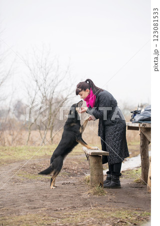 Woman scratching her dog and giving it a high five Woman scratching her dog and giving it a high five 123081533