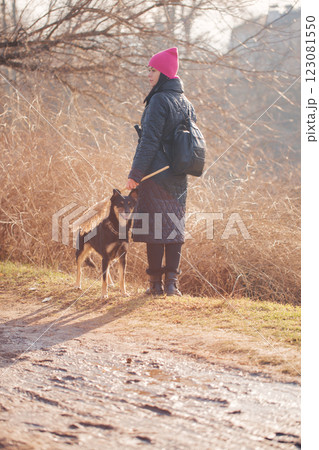 Woman in hat walking with dog, photo from the back 123081550