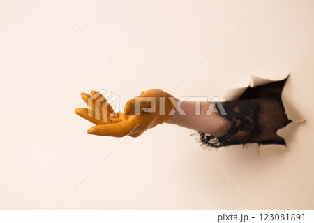 A woman's hand in a leather yellow glove shows a gesture of request 123081891