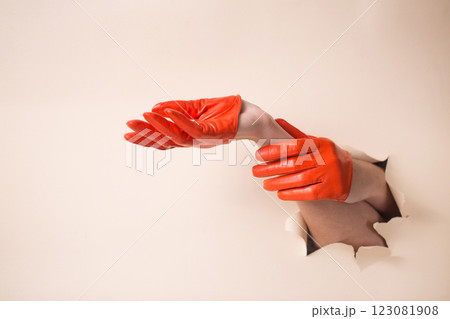 A woman's hands in a orange gloves shows a gesture 123081908