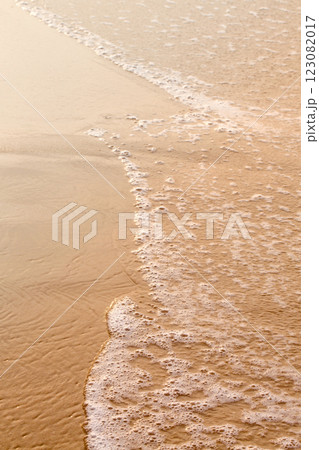 An ocean beach with calm waves. The water is clear and the sand is golden An ocean beach with calm waves. The water is clear and the sand is golden 123082017