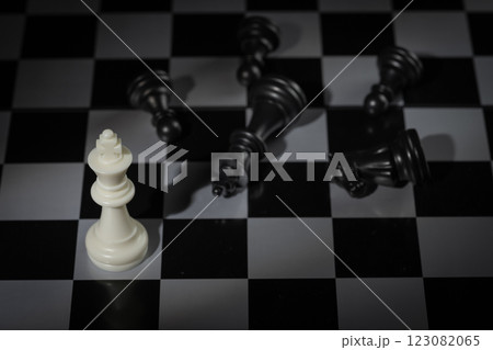 A close-up of a chessboard highlighting the white KING standing out among black pieces, symbolizing strategic thinking, leadership, and decisive planning in overcoming challenges and achieving goals. 123082065