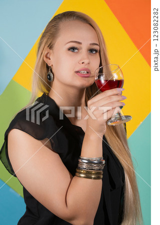 Cheerful blonde woman holding two glasses of red wine and smiling Cheerful blonde woman holding two glasses of red wine and smiling 123082282