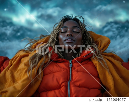 Young woman lying in snow enjoying northern lights 123084077