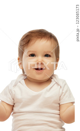Portrait of little baby smiling brightly while looking directly forward with joyful expression against white background. 123085173