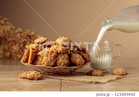 Oatmeal cookies and milk sit on a kitchen table. 123085692