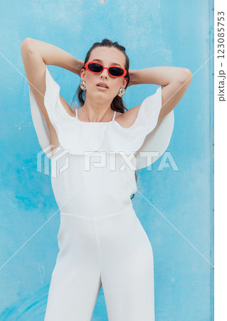 Beautiful Brunette Woman in White Suit on Blue Background Beautiful Brunette Woman in White Suit on Blue Background 123085753