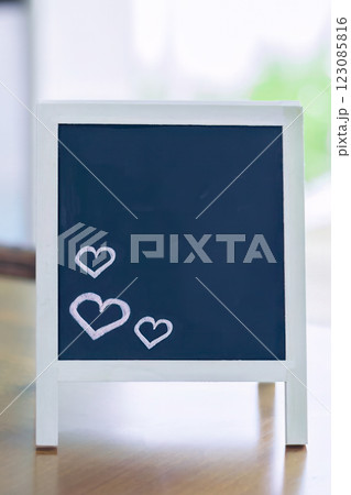 Cute black wooden chalkboard with hand-drawn white hearts in a romantic setting Cute black wooden chalkboard with hand-drawn white hearts in a romantic setting 123085816