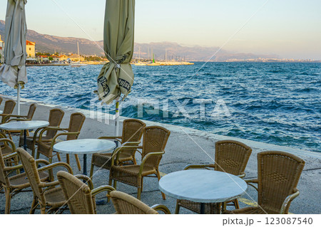 Empty waterfront promenade cafe without visitors after the end of the season, water splashes 123087540