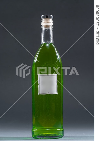 bottle with homemade alcohol tincture or liquor, mockup with empty label, tarragon and peppermint 123088039